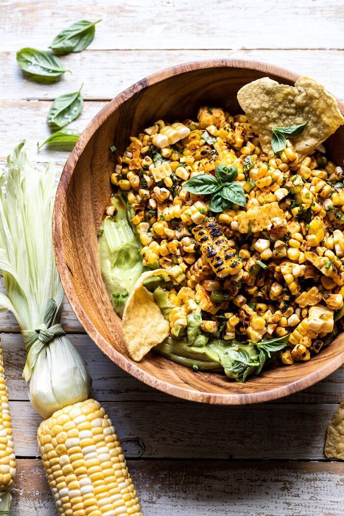 Grilled Street Corn Salad with Avocado Mayo | halfbakedharvest.com #corn #salad #easyrecipes #summer overhead photo of Grilled Street Corn Salad with Avocado Mayo in salad bowl with chips in avocado