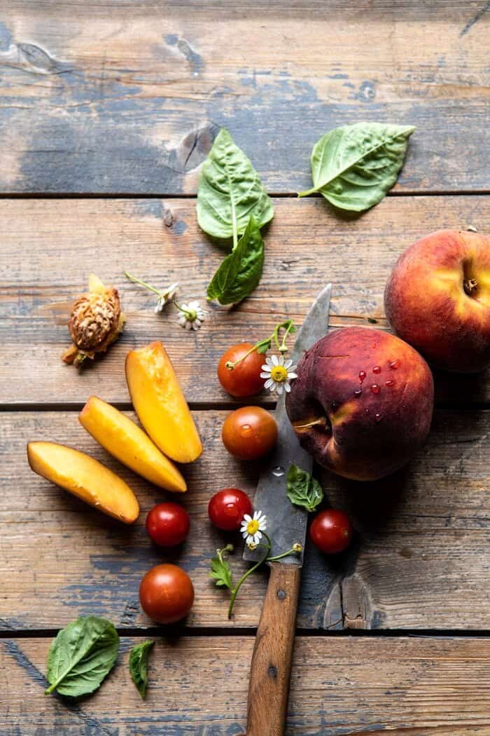 Peach Caprese Salad with Toasted Garlic Naan | halfbakedharvest.com #salad #peaches #burrata Peaches and tomatoes on wood surface