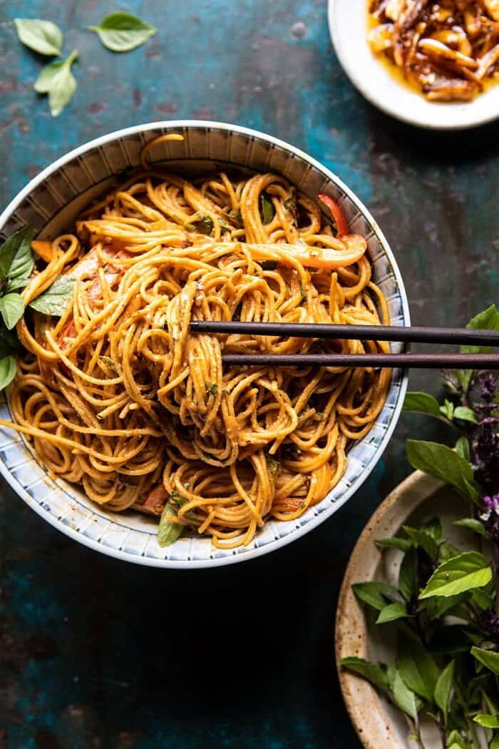 Spicy Peanut Noodles with Chili Garlic Oil | halfbakedharvest.com #peanutnoodles #easyrecipes #dinner #healthy overhead photo of Spicy Peanut Noodles with Chili Garlic Oil and chopsticks in bowl