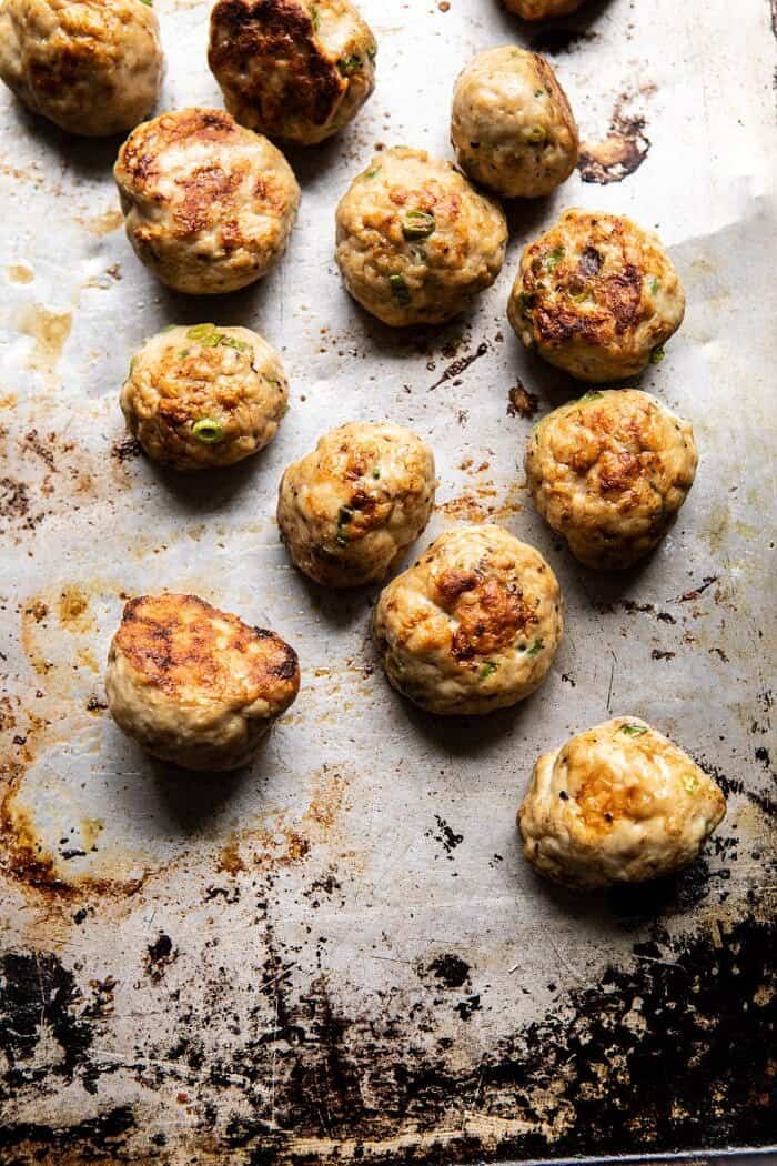 Weeknight 30 Minute Coconut Curry Chicken Meatballs | halfbakedharvest.com #curry #meatballs #healthy overhead photo of Chicken Meatballs on baking sheet after baking