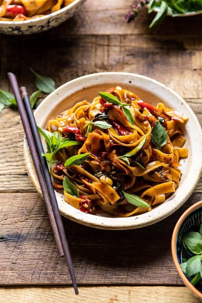 Better Than Takeout Thai Drunken Noodles | halfbakedharvest.com #takeout #noodles #weeknightrecipe #Thai side angle photo of Better Than Takeout Thai Drunken Noodles with chopsticks resting on bowl