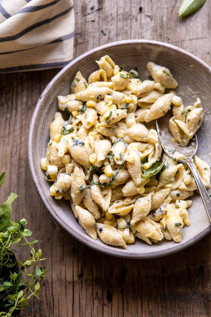 One Pot Lemon Basil, Corn, and Ricotta Pasta | halfbakedharvest.com #onepot #easyrecipes #pasta #summer overhead photo of One Pot Lemon Basil, Corn, and Ricotta Pasta in single serving bowl with spoon in bowl