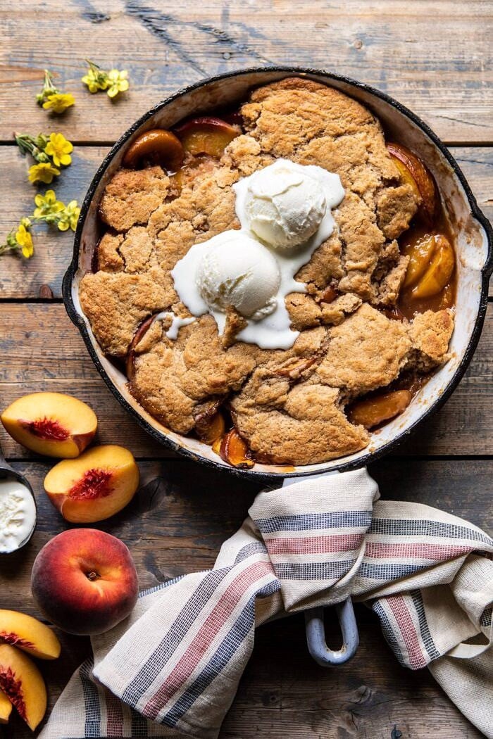 Skillet Brown Sugar Peach Cobbler | halfbakedharvest.com #peach #summer #easyrecipes #cobbler overhead photo of Skillet Brown Sugar Peach Cobbler with 2 scoops of ice cream on top