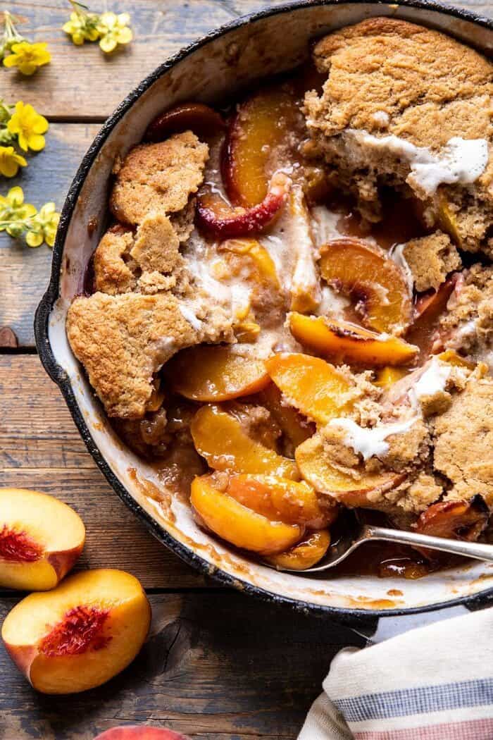 Skillet Brown Sugar Peach Cobbler | halfbakedharvest.com #peach #summer #easyrecipes #cobbler overhead close up photo of Skillet Brown Sugar Peach Cobbler with spoonfuls removed from cobbler
