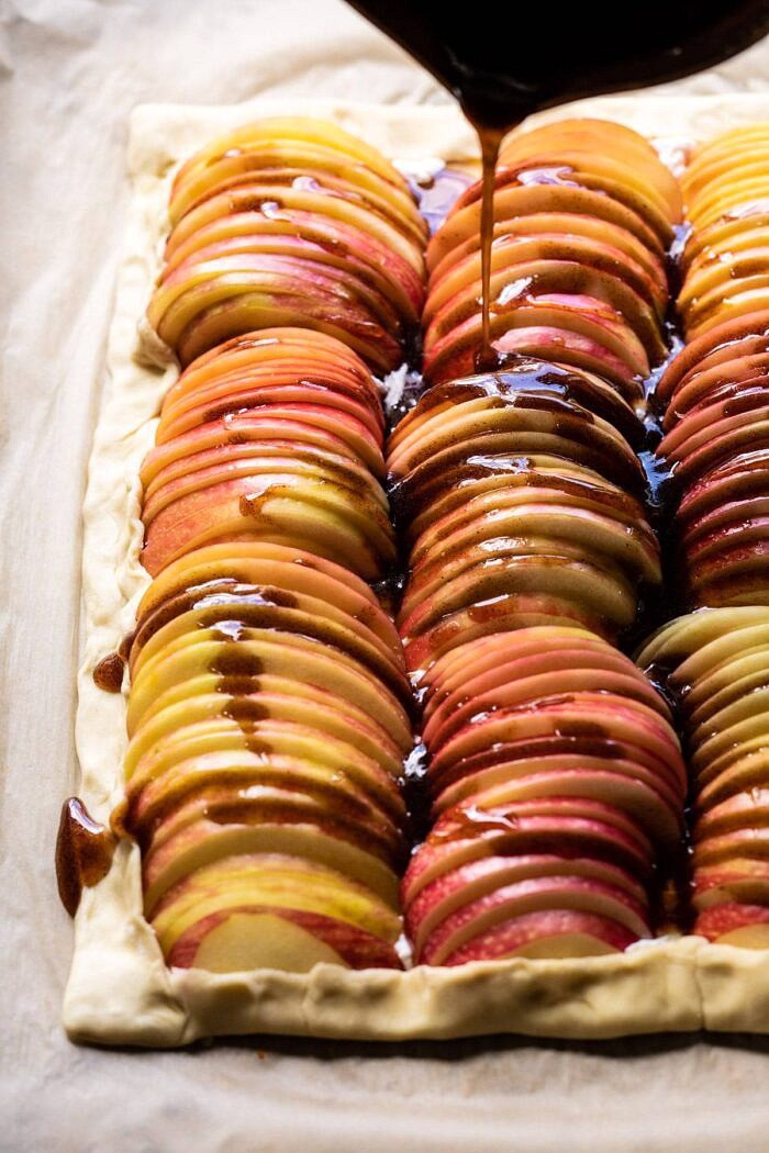 Chai Spiced Apple Ricotta Galette | halfbakedhavest.com #apple #pastry #fallrecipes #autumn side angled photo of maple syrup being drizzled over top the apples before baking