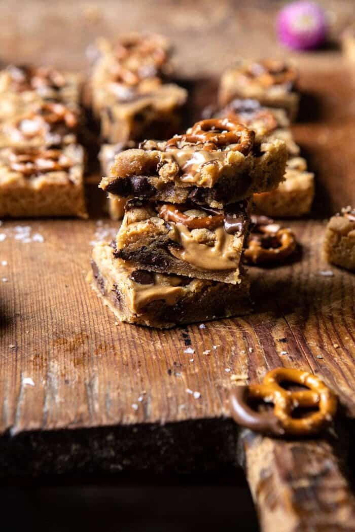 Chocolate Peanut Butter Pretzel Blondies | halfbakedharvest.com #peanutbutter #chocolate #pretzels #fall #autumn #dessert side angled photo of Chocolate Peanut Butter Pretzel Blondies stacked on top of each other
