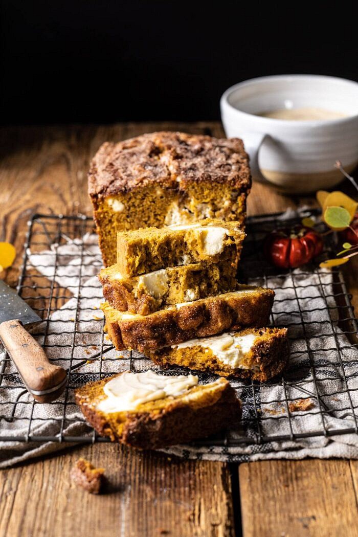 Cream Cheese Swirled Pumpkin Bread with Salted Maple Butter | halfbakedharvest.com #easyrecipes #pumpkinbread #pumpkin #fallrecipes side angled photo of Cream Cheese Swirled Pumpkin Bread with multiple slices cut and stacked on top of each other