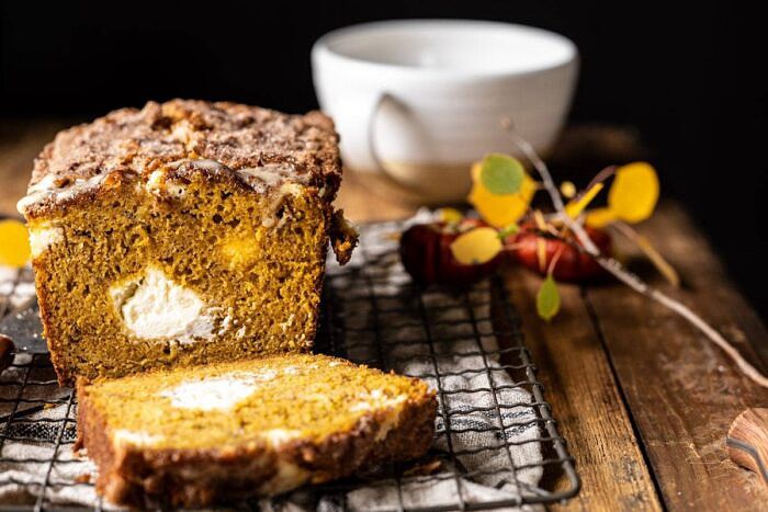 Cream Cheese Swirled Pumpkin Bread with Salted Maple Butter | halfbakedharvest.com #easyrecipes #pumpkinbread #pumpkin #fallrecipes horizontal photo of Cream Cheese Swirled Pumpkin Bread with 1 slice cut