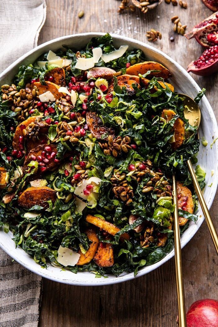 Fall Harvest Roasted Butternut Squash and Pomegranate Salad | halfbakedharvest.com #salad #autumnrecipes #easyrecipes #healthy #butternutsquash overhead photo of Fall Harvest Roasted Butternut Squash and Pomegranate Salad after being tossed with salad spoons in salad bowl