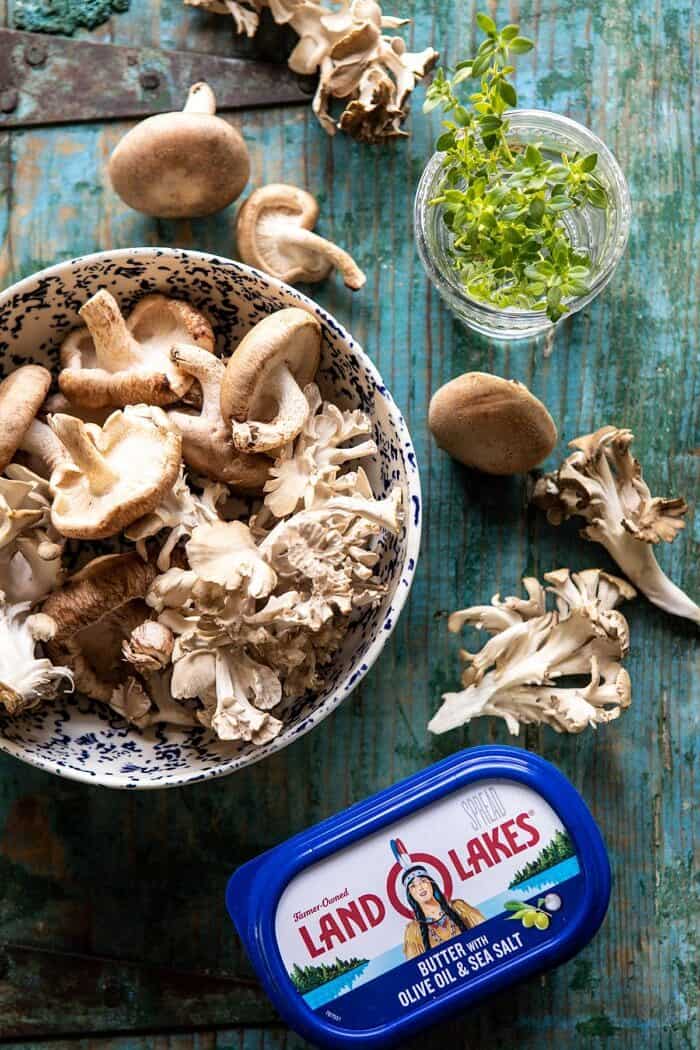 Pesto Polenta with Thyme Roasted Mushrooms and Chickpeas | halfbakedharvest.com #pesto #polenta #mushrooms #easyrecipes overhead photo of raw mushrooms and butter