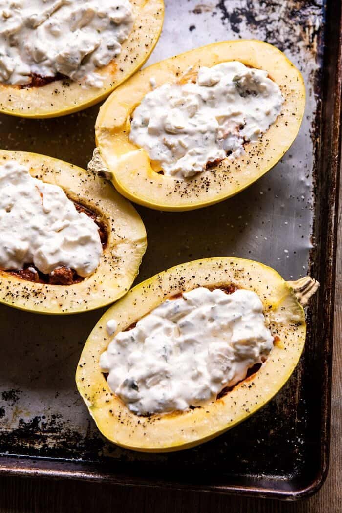 overhead photo of Roasted Garlic Spaghetti Squash Lasagna Boats before baking with cheese sauce