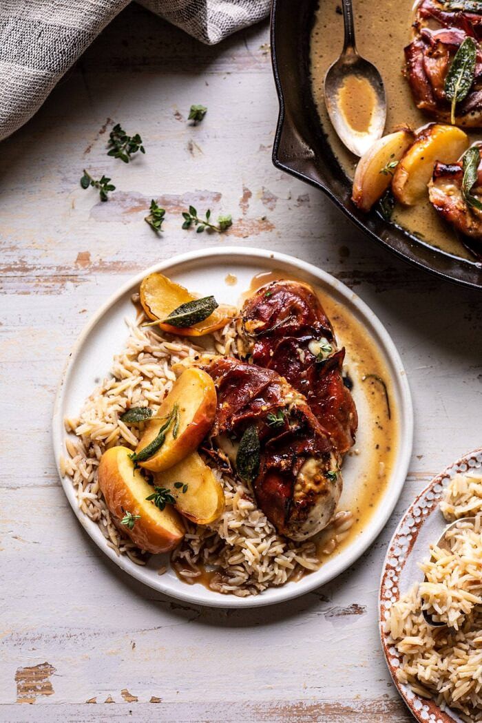 Prosciutto Apple and Sage Butter Chicken with Cider Pan Sauce | halfbakedharvest.com #chicken #apples #fallrecipes #skillet overhead photo of Prosciutto Apple and Sage Butter Chicken with Cider Pan Sauce on a plate with rice pilaf