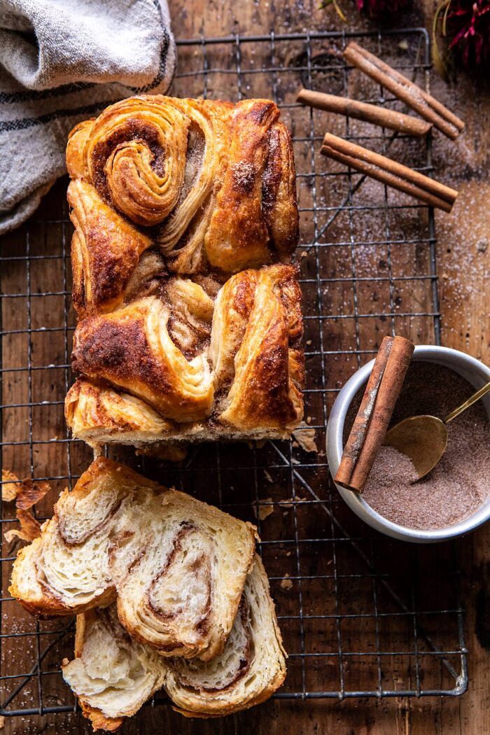 Easy Swirled Cinnamon Sugar Croissant Loaf | halfbakedharvest.com #cinnamon #fall #bread #croissants overhead photo of Easy Swirled Cinnamon Sugar Croissant Loaf with 2 slices of bread cut and cinnamon sugar in photo