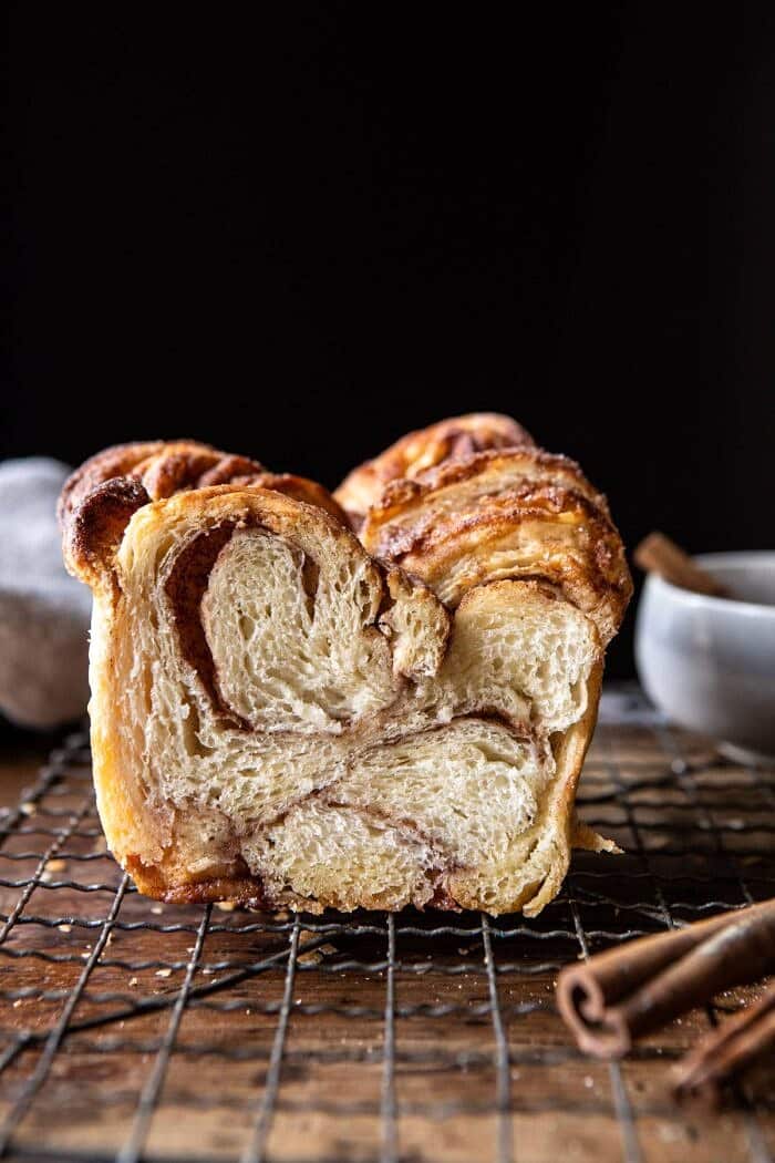 Easy Swirled Cinnamon Sugar Croissant Loaf | halfbakedharvest.com #cinnamon #fall #bread #croissants side angled photo of Easy Swirled Cinnamon Sugar Croissant Loaf with loaf cut in half to show the inside