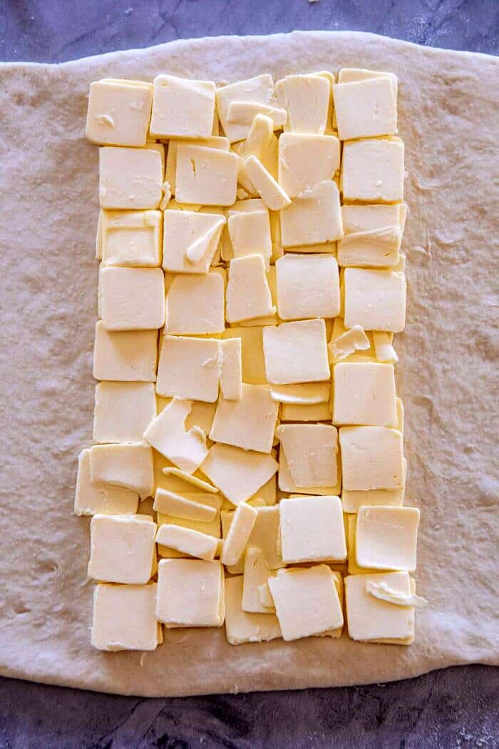 Easy Swirled Cinnamon Sugar Croissant Loaf | halfbakedharvest.com #cinnamon #fall #bread #croissants overhead close up of butter on dough