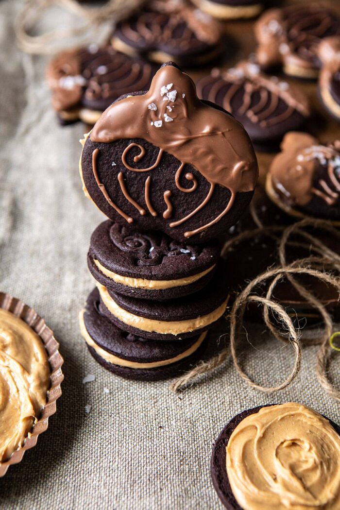 Peanut Butter Stuffed Chocolate Jack-O’-Lantern Cookies | halfbakedharvest.com #peanutbbutter #chocolate #cookies #halloween #thanksgiving side angle photo of Peanut Butter Stuffed Chocolate Jack-O’-Lantern Cookies stacked on top of each other