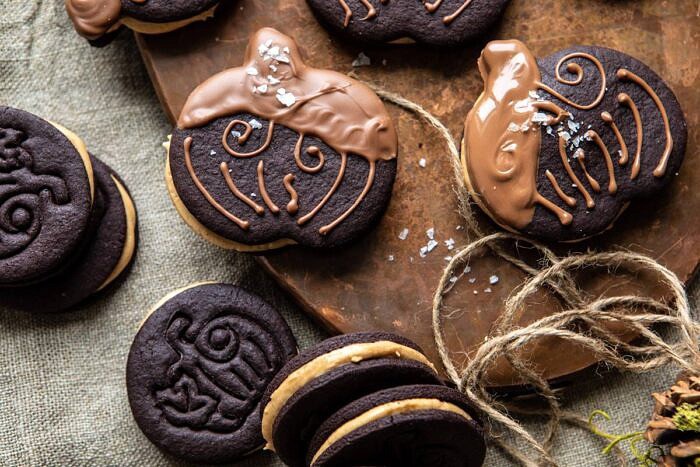 Peanut Butter Stuffed Chocolate Jack-O’-Lantern Cookies | halfbakedharvest.com #peanutbbutter #chocolate #cookies #halloween #thanksgiving overhead horizontal photo of Peanut Butter Stuffed Chocolate Jack-O’-Lantern Cookies