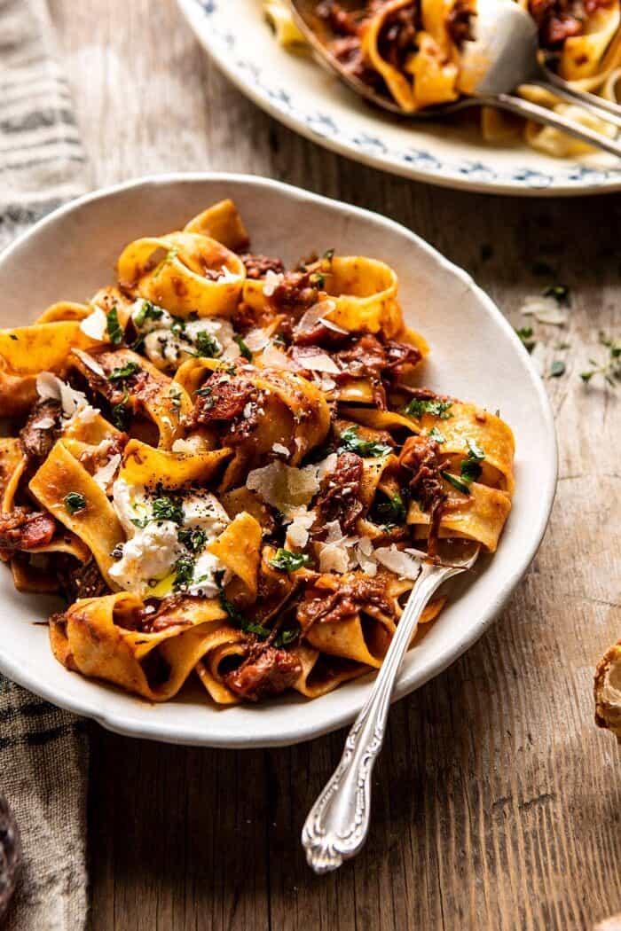 Slow Cooker Red Wine Sunday Ragu Pasta | halfbakedharvest.com #pasta #ragu #Italian #slowcooker #crockpot #instantpot side angled photo of Slow Cooker Red Wine Sunday Ragu Pasta with fork in bowl