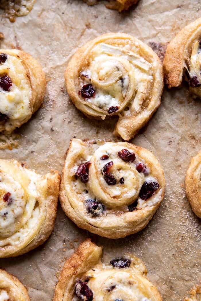 5 Ingredient Cranberry Brie Cinnamon Puff Pastry Swirls | halfbakedharvest.com #brie #cranberries #thanksgiving #christmas overhead photo of 5 Ingredient Cranberry Brie Cinnamon Puff Pastry Swirls on baking sheet after baking