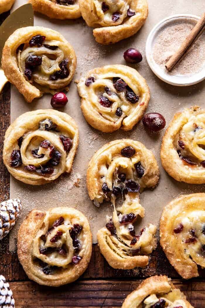 5 Ingredient Cranberry Brie Cinnamon Puff Pastry Swirls | halfbakedharvest.com #brie #cranberries #thanksgiving #christmas overhead photo of 5 Ingredient Cranberry Brie Cinnamon Puff Pastry Swirls with cheese being pulled out of swirl