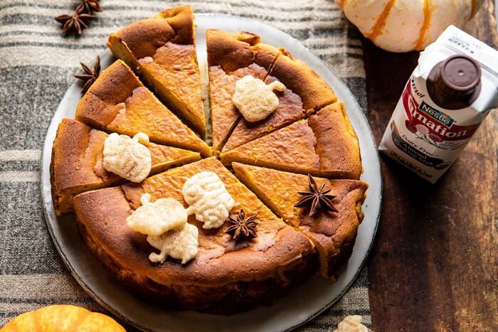 Burnt Basque Pumpkin Spice Cheesecake | halfbakedharvest.com #pumpkin #cheesecake #thanksgiving horizontal photo of Burnt Basque Pumpkin Spice Cheesecake with almond milk in photo next to cheesecake