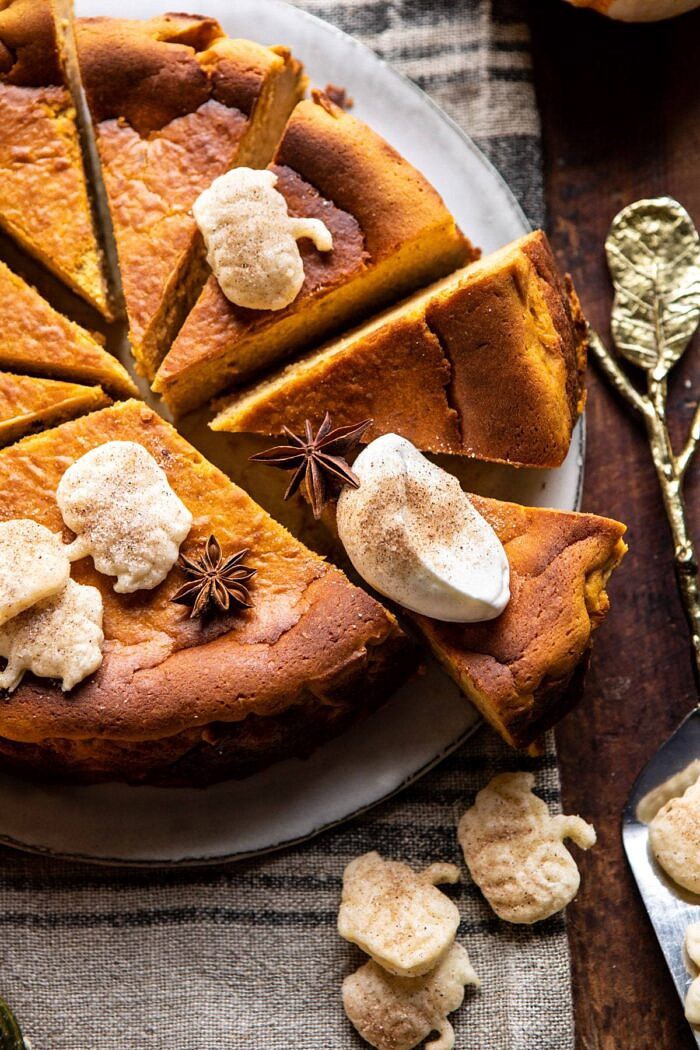 Burnt Basque Pumpkin Spice Cheesecake | halfbakedharvest.com #pumpkin #cheesecake #thanksgiving side angled close up photo of Burnt Basque Pumpkin Spice Cheesecake with whipped cream on slice