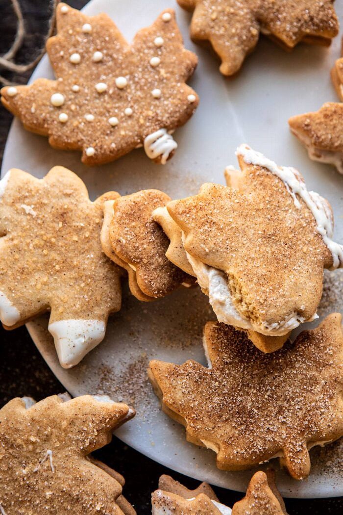 Chai Spiced Maple Sugar Cookies with Browned Butter Frosting | halfbakedharvest.com #cookies #thanksgiving #dessert #holiday #sugarcookies overhead photo of Chai Spiced Maple Sugar Cookie with Browned Butter Frosting broken in half to expose the filling