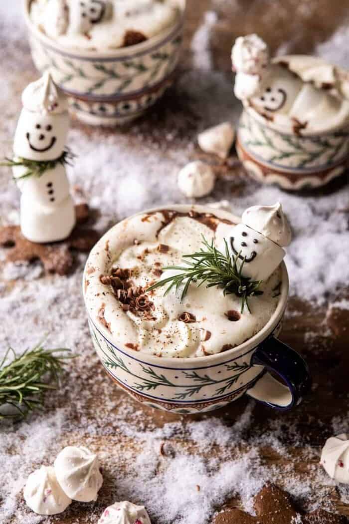 Creamy Coconut Hot Chocolate | halfbakedharvest.com #hotchocolate #easyrecipe #christmas #dessert overhead photo of Creamy Coconut Hot Chocolate with melting snowman marshmallow in hot cocoa
