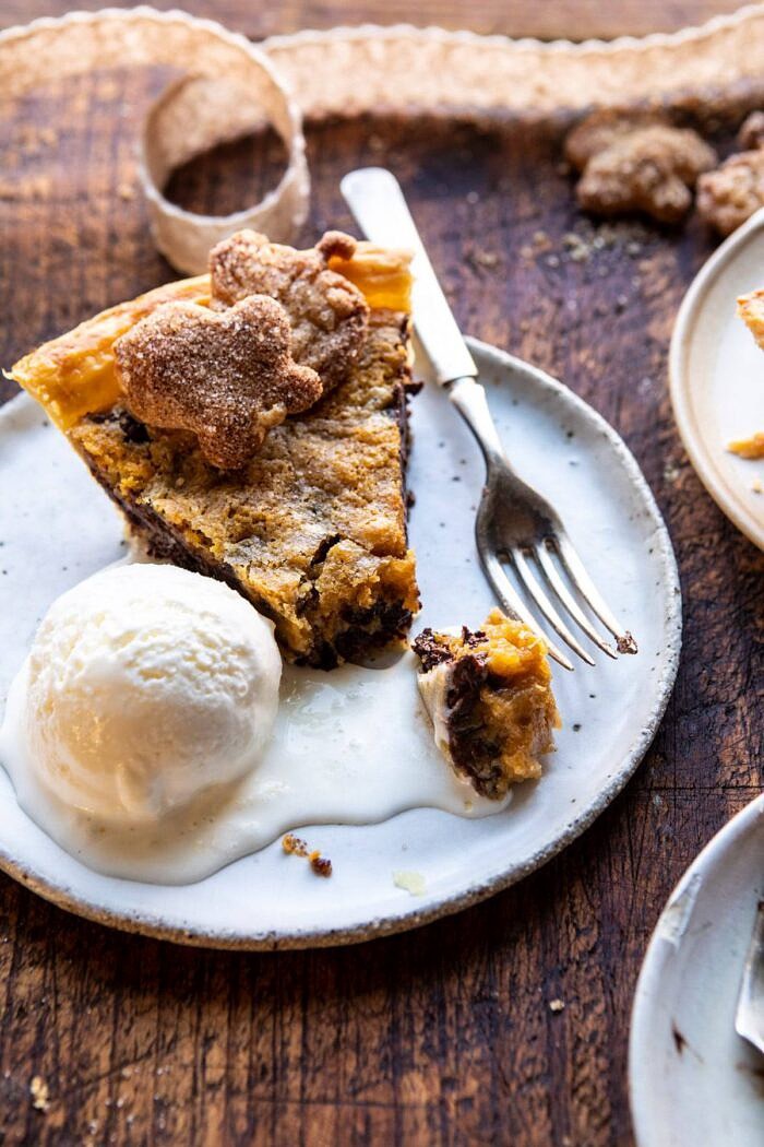 Gooey Chocolate Chip Cookie Pumpkin Pie | halfbakedharvest.com #cookiepie #thanksgiving #pumpkinpie overhead photo of Gooey Chocolate Chip Cookie Pumpkin Pie slice with ice cream on plate