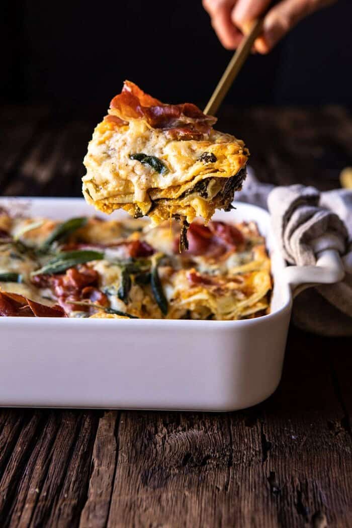 Roasted Butternut Squash and Spinach Lasagna | halfbakedharvest.com #lasagna #holiday #thanksgiving side angled photo of Roasted Butternut Squash and Spinach Lasagna with serving of lasagna being removed from dish