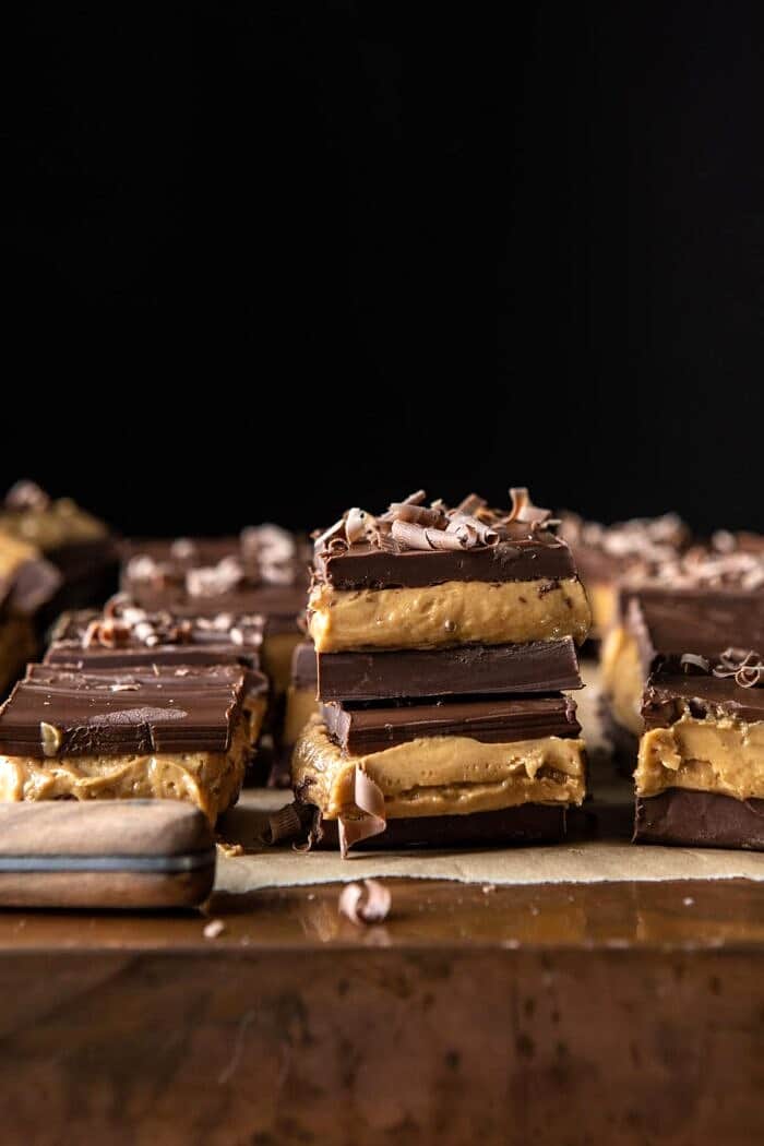 5 Ingredient Triple Decker Chocolate Peanut Butter Bars | halfbakedharvest.com #peanutbutter #chocolate side angled photo of 5 Ingredient Triple Decker Chocolate Peanut Butter Bars