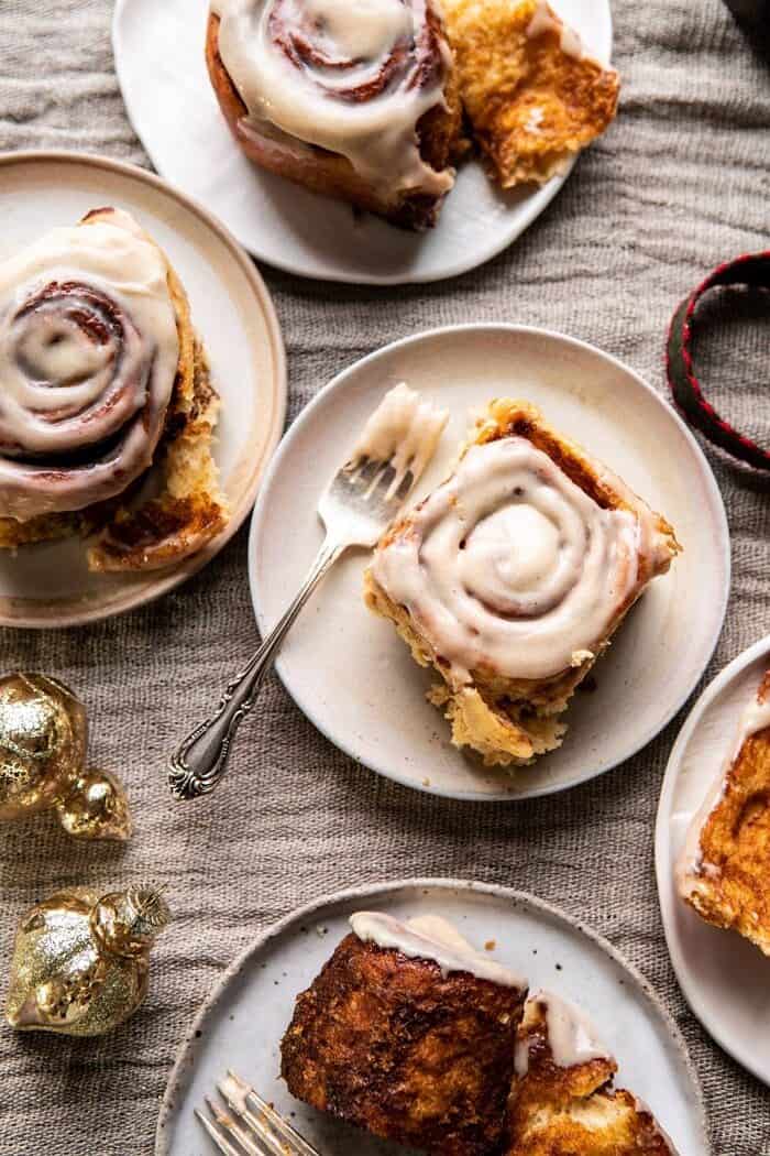 Easy Gingerbread Brioche Cinnamon Rolls | halfbakedharvest.com #cinnamonrolls #gingerbread overhead photo of Easy Gingerbread Brioche Cinnamon Rolls on plates with forks