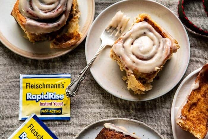 Easy Gingerbread Brioche Cinnamon Rolls | halfbakedharvest.com #cinnamonrolls #gingerbread horizontal photo of Easy Gingerbread Brioche Cinnamon Rolls on plates with forks