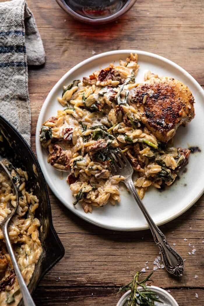 One Skillet Creamy Sun-Dried Tomato Chicken and Orzo | halfbakedharvest.com #skilletdinner #chicken #orzo overhead photo One Skillet Creamy Sun-Dried Tomato Chicken and Orzo plated with fork on plate