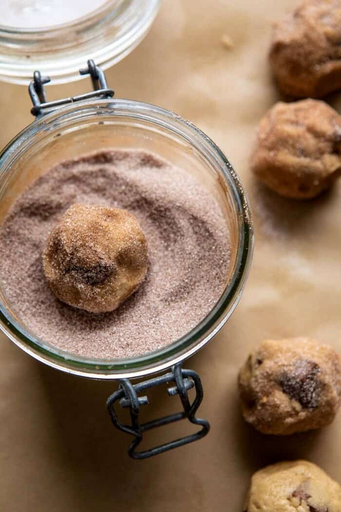 Salted Caramel Pretzel Snickerdoodles | halfbakedharvest.com #cookies #snickerdoodles #christmas overhead photo of Salted Caramel Pretzel Snickerdoodles cookie dough being rolled in cinnamon sugar