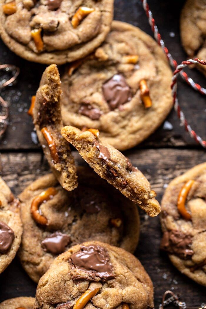 Salted Caramel Pretzel Snickerdoodles | halfbakedharvest.com #cookies #snickerdoodles #christmas close up photo of Salted Caramel Pretzel Snickerdoodle cookie broken in half