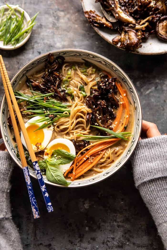 30 Minute Creamy Sesame Miso Ramen with Crispy Mushrooms | halfbakedharvest.com overhead photo of 30 Minute Creamy Sesame Miso Ramen with Crispy Mushrooms with hands on soup bowl