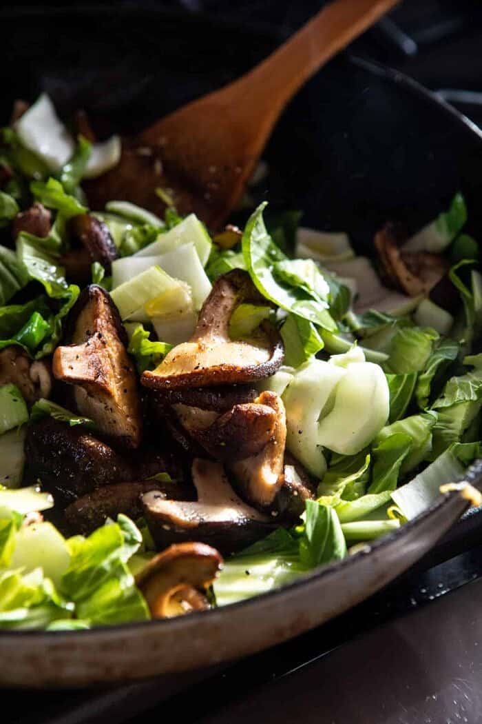 side angled prep photo of vegetables cooking in skillet on stove