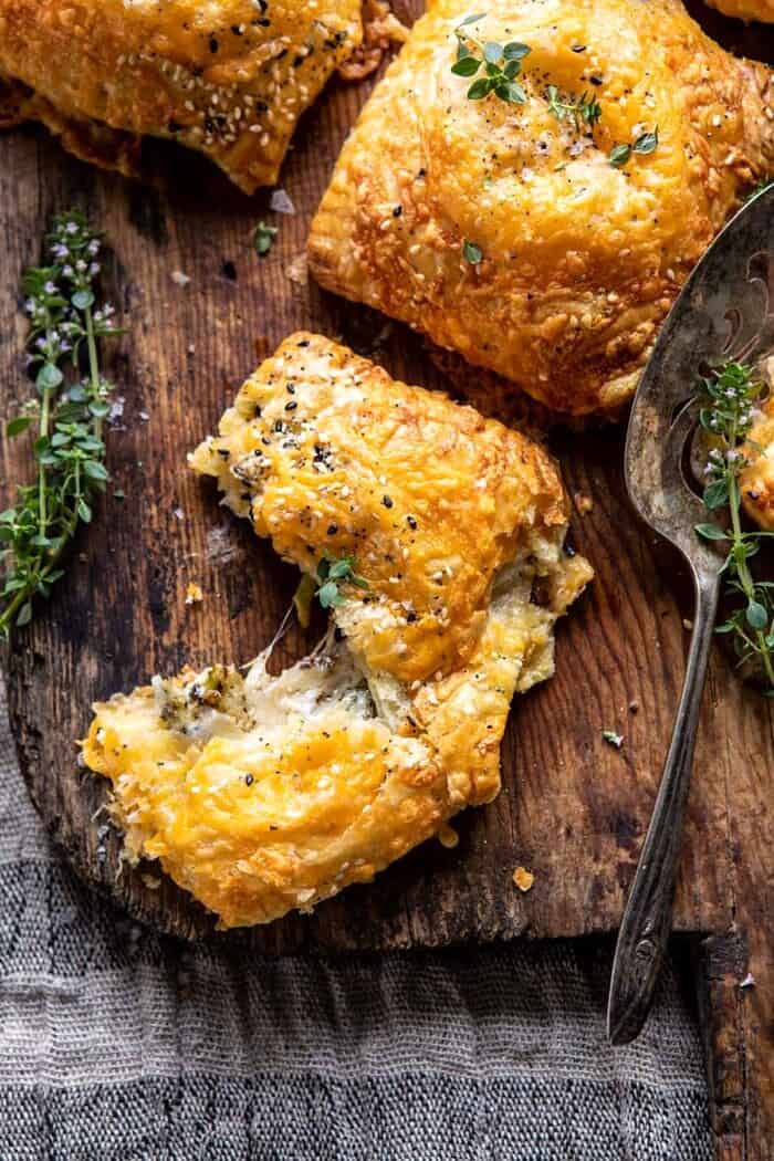 overhead photo of Flaky Broccoli Cheddar Soup Mini Pies torn in half to expose the filling 