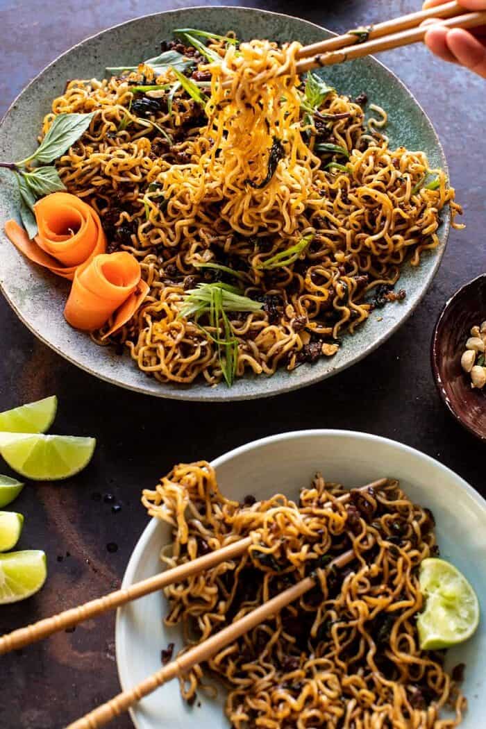 side angled photo of 30 Minute Caramelized Shallot Beef Ramen Noodles with chopsticks pulling the noodles out of the bowl 