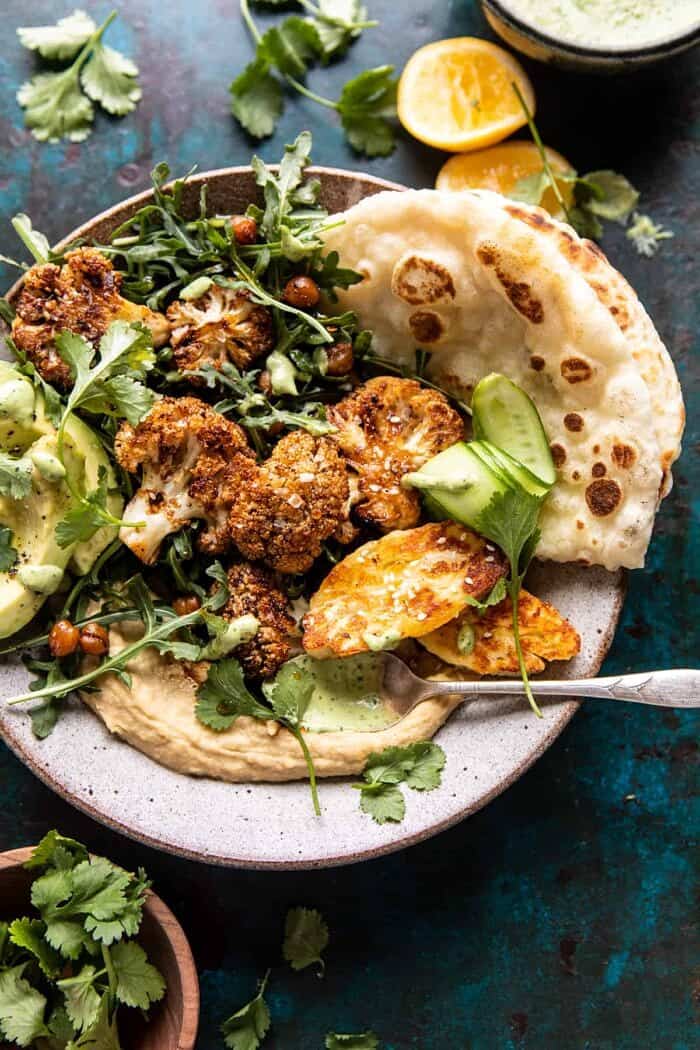 Cauliflower Shawarma with Green Tahini and Fried Halloumi | halfbakedharvest.com overhead photo of Cauliflower Shawarma with Green Tahini and Fried Halloumi and spoon full of green tahini in bowl