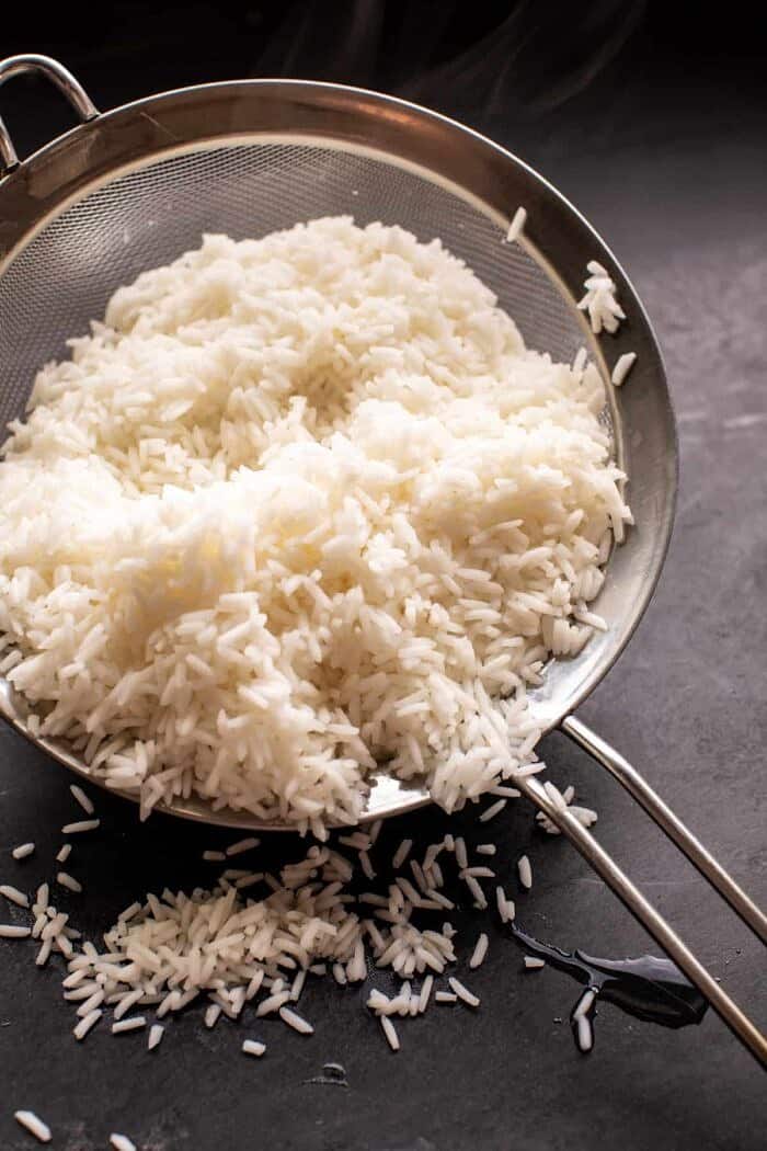 par cooked rice in mesh sieve after boiling