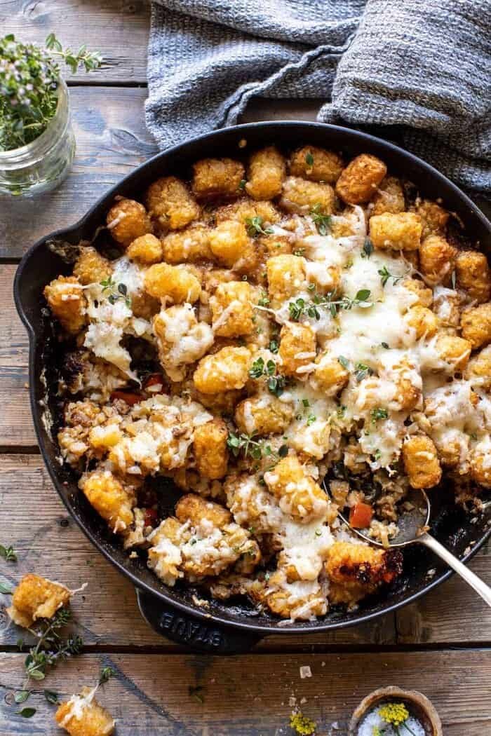 One Skillet French Onion Tater Tot Casserole | halfbakedharvest.com One Skillet French Onion Tater Tot Casserole with spoon in skillet and portions of casserole removed from skillet