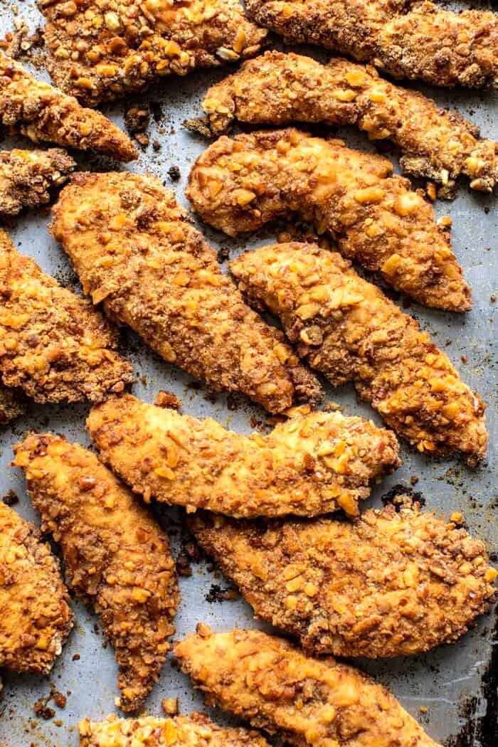 overhead prep photo of Spicy Honey Mustard Pretzel Chicken Fingers sitting on baking sheet after baking