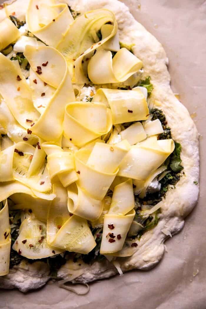 Garden Greens Goddess Pizza | halfbakedharvest.com overhead prep photo of Garden Greens Goddess Pizza on baking sheet before baking