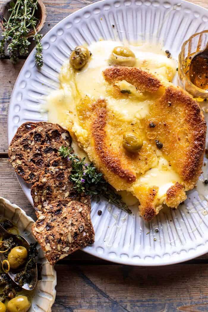 Pan Fried Brie with Peppered Honey and Olives | halfbakedharvest.com overhead photo of Pan Fried Brie with Peppered Honey and Olives and the brie is broken into and oozing out