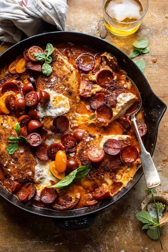 Skillet Cheesy Pepperoni Pizza Chicken | halfbakedharvest.com overhead photo of Skillet Cheesy Pepperoni Pizza Chicken with 1 piece of chicken in half