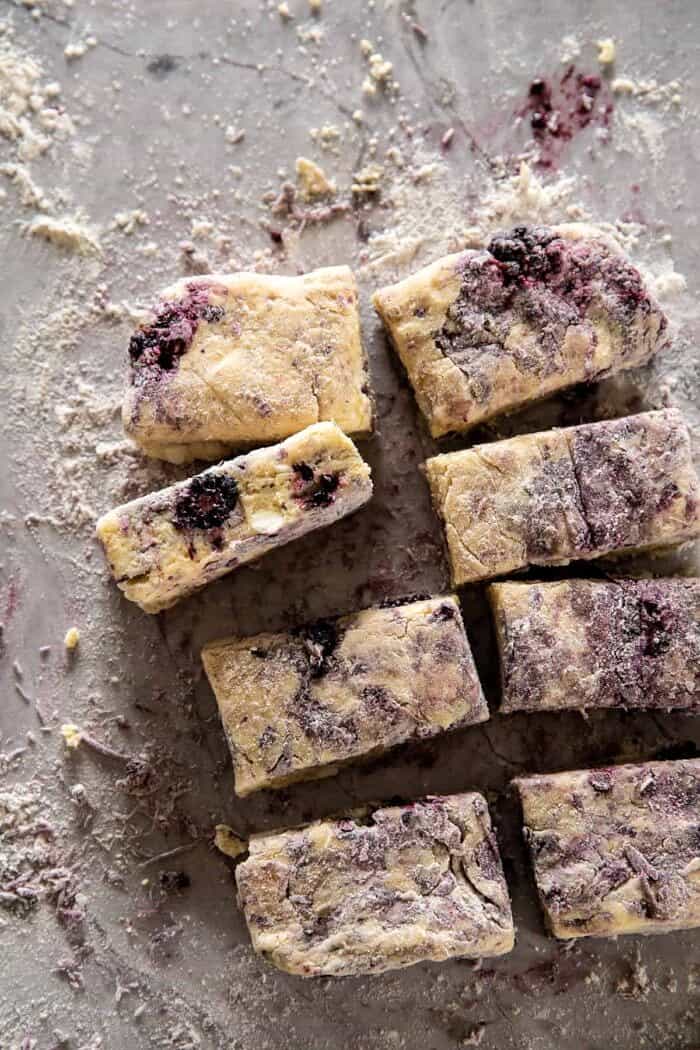Blackberry Lavender White Chocolate Scones | halfbakedharvest.com oveherad photo of Blackberry Lavender White Chocolate Scone dough on counter after cutting into squares