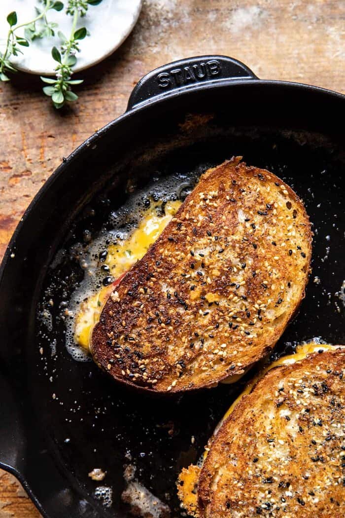 overhead photo of Everything Cheddar Tomato Bacon Grilled Cheese in skillet 