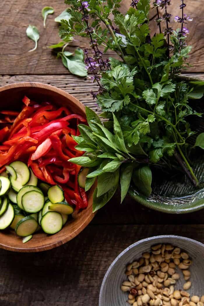 Saucy Thai Summer Noodle Stir Fry with Sesame Peanuts | halfbakedharvest.com overhead prep photo of raw vegetables, herbs, and peanuts